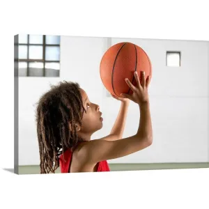 "Boy aiming a shot with a basketball in a school sports hall." Canvas Wall Art