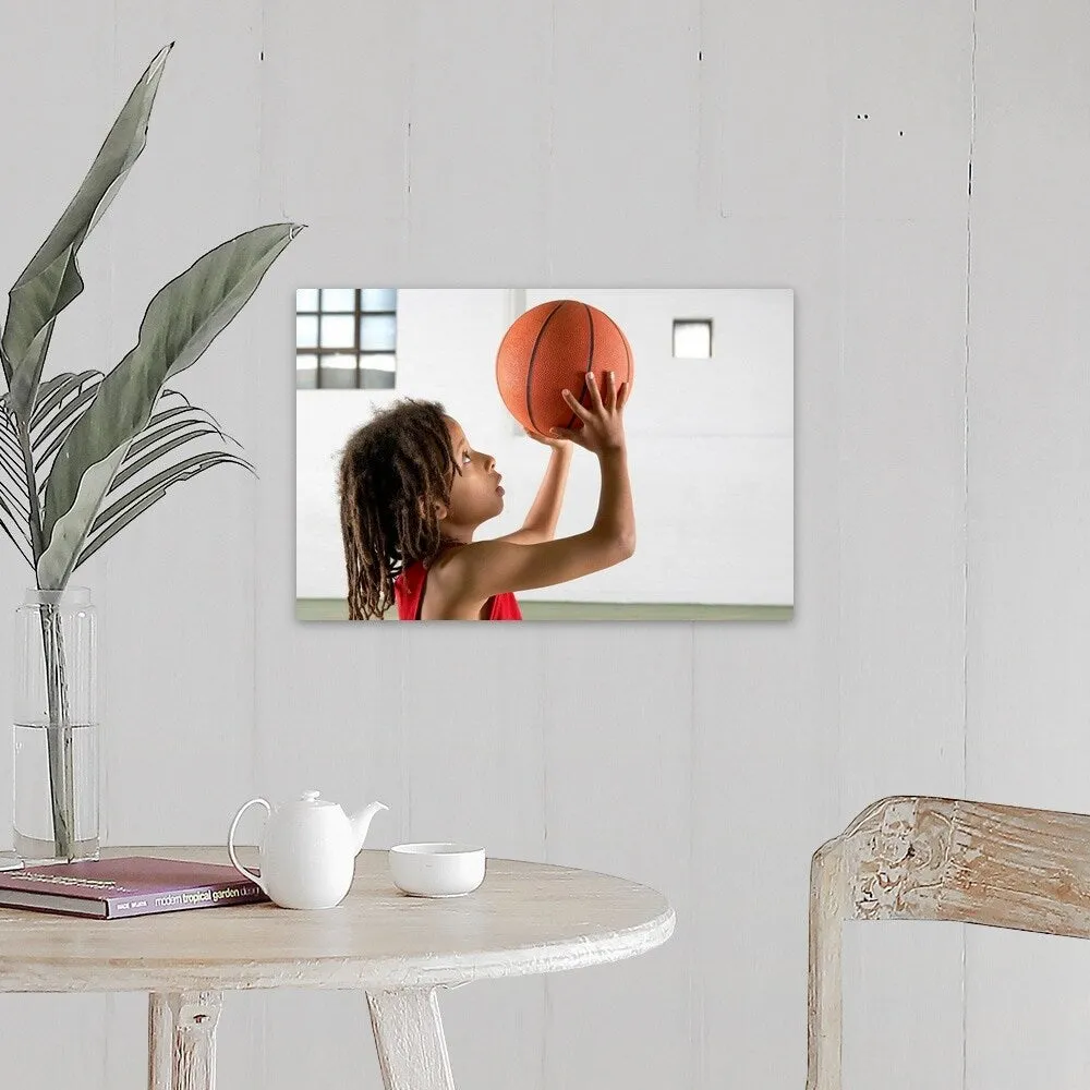 "Boy aiming a shot with a basketball in a school sports hall." Canvas Wall Art